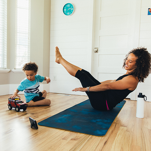 women exercising on mat with child near